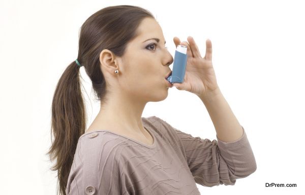 portrait of young women woman using asthma inhaler