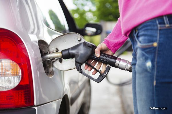 Closeup of woman pumping gasoline fuel in car at gas station. Petrol or gasoline being pumped into a motor vehicle car.