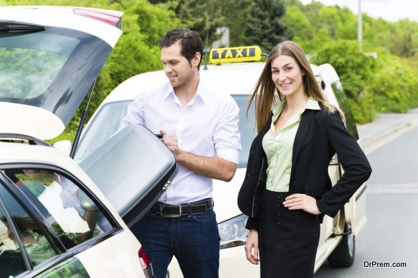 Young businesswoman in front of taxi with luggage