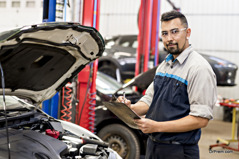 A Handsome mechanic job in uniform working on car