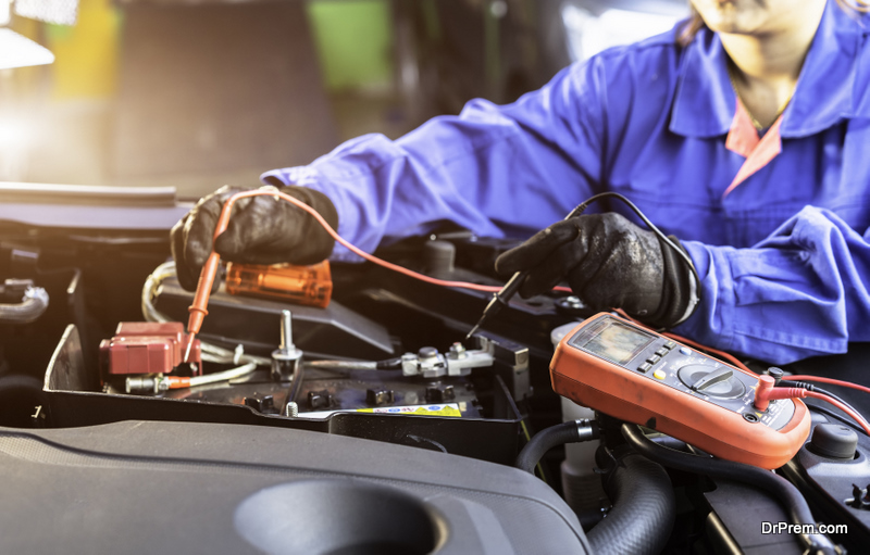 Asian technician measure voltage of battery in the car at service station, Maintenance and repair