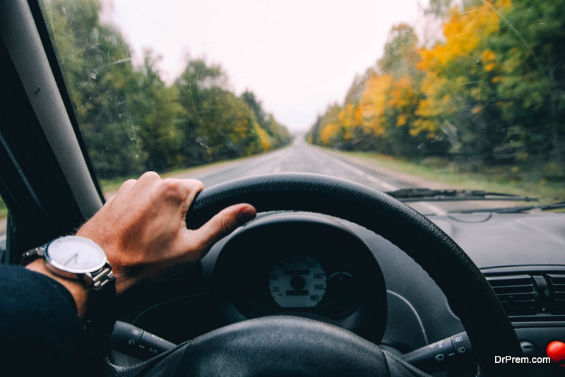 car driver holds the wheel on a sunny day.